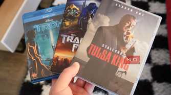 Blu-ray discs and DVDs in the hand.