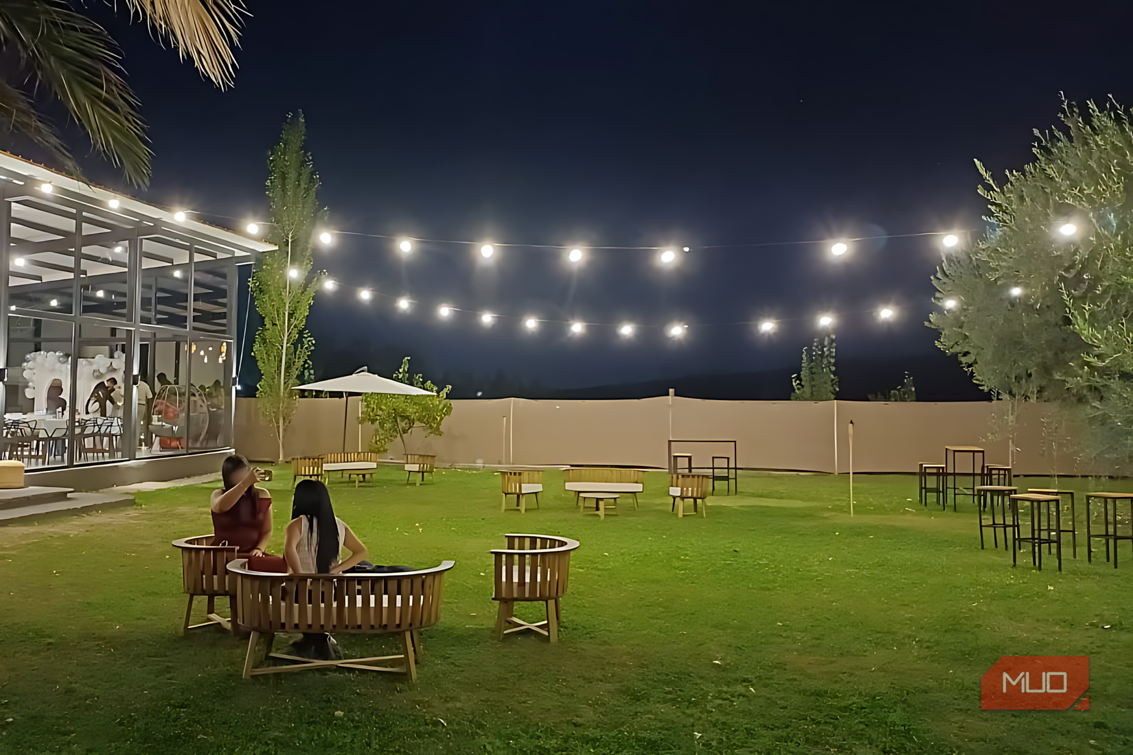 Nighttime photo of an outdoor seating area under string lights