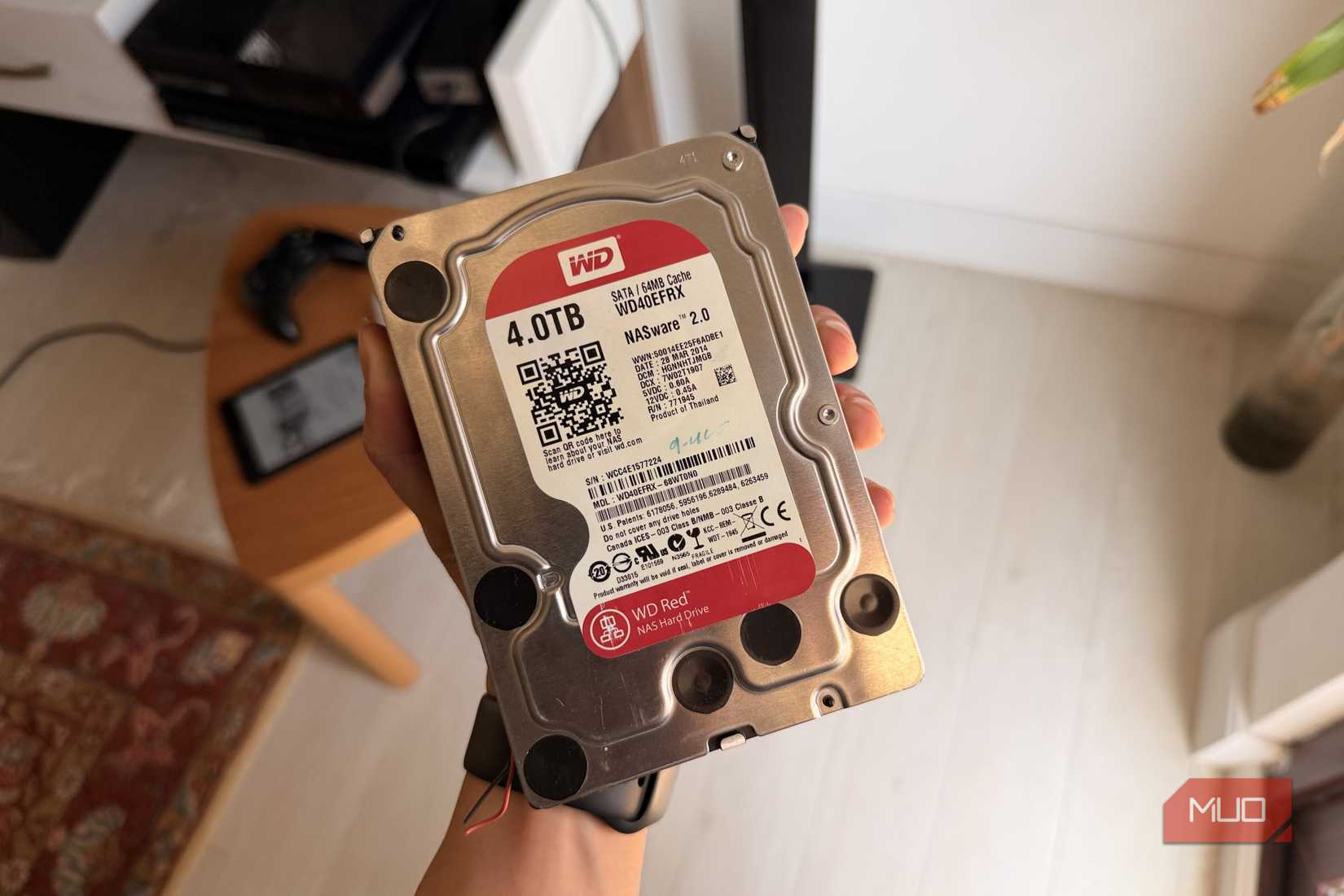 Hand holding a WD Red 4TB NAS hard drive showing its label