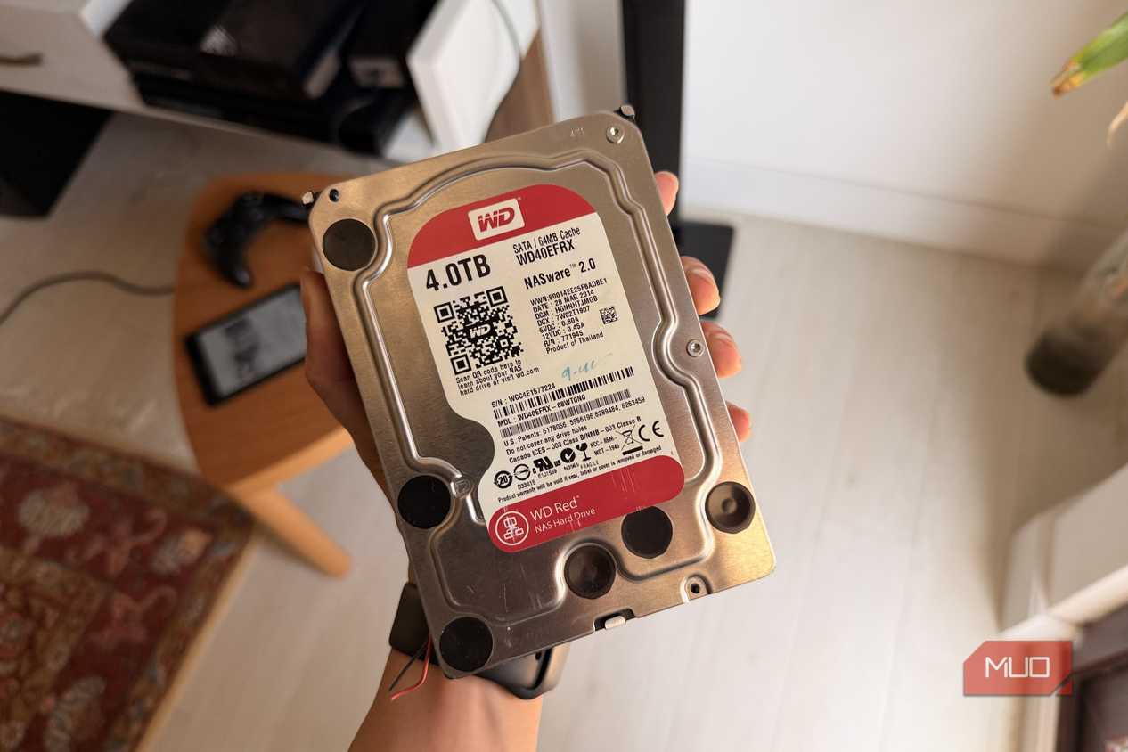 Hand holding a WD Red 4TB NAS hard drive showing its label