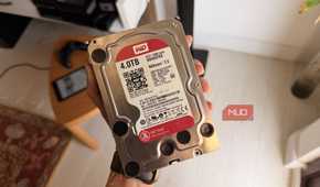 Hand holding a WD Red 4TB NAS hard drive showing its label