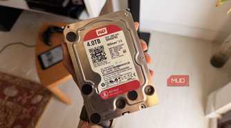 Hand holding a WD Red 4TB NAS hard drive showing its label