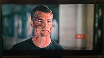 A bloody Peter in a scene from The Night Agent playing on a Hisense TV.