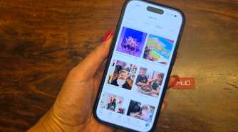 A hand holding an iPhone showing a Facebook photo album.