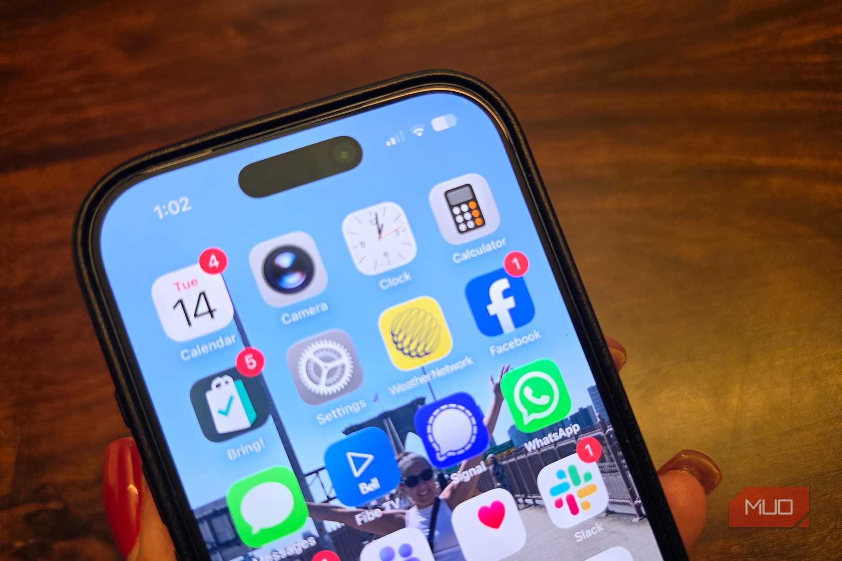 An iPhone on an angle showing app icons, including Facebook.