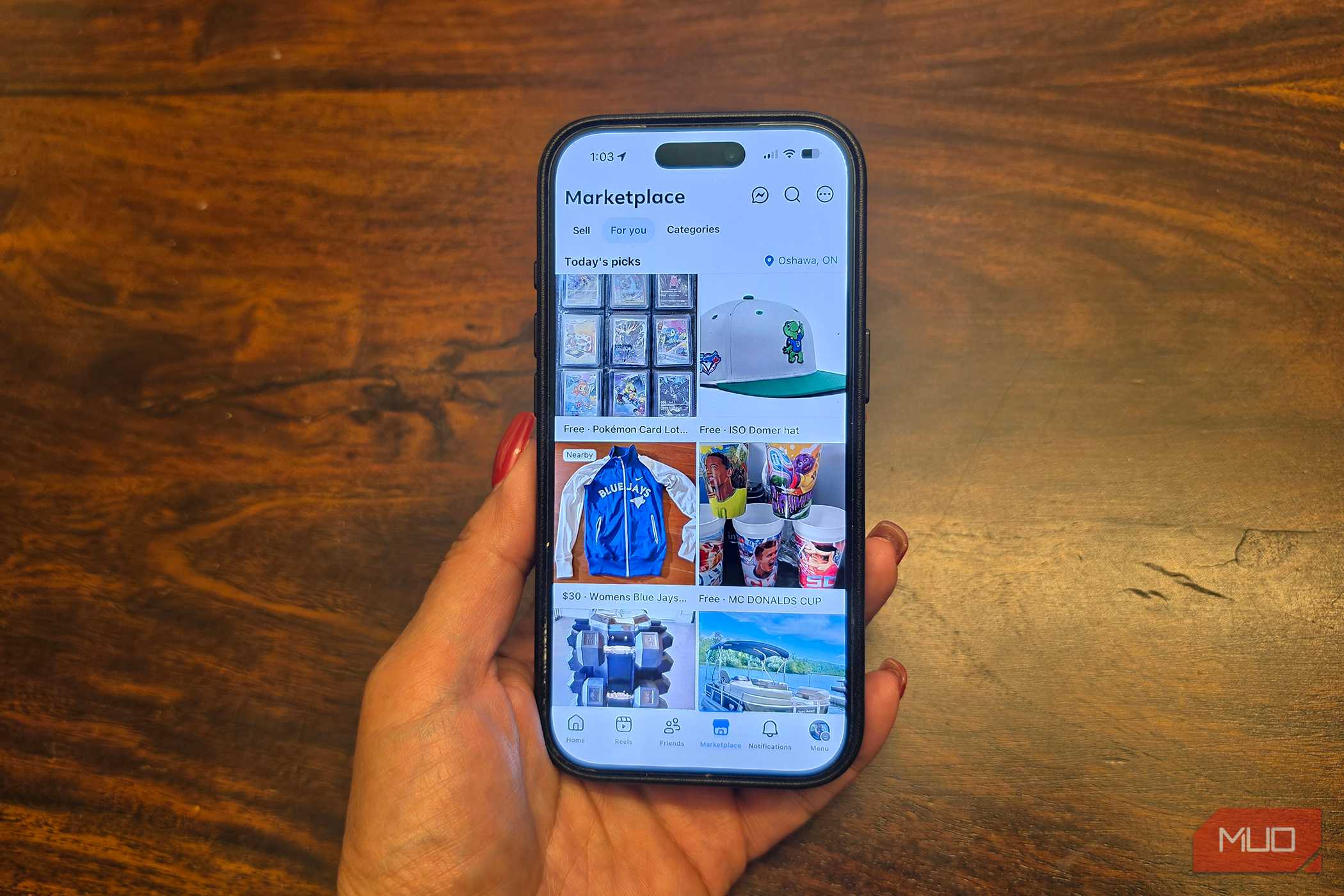 An iPhone in hand showing listings on Facebook Marketplace.