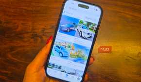 An iPhone in hand showing car listings on Facebook Marketplace.