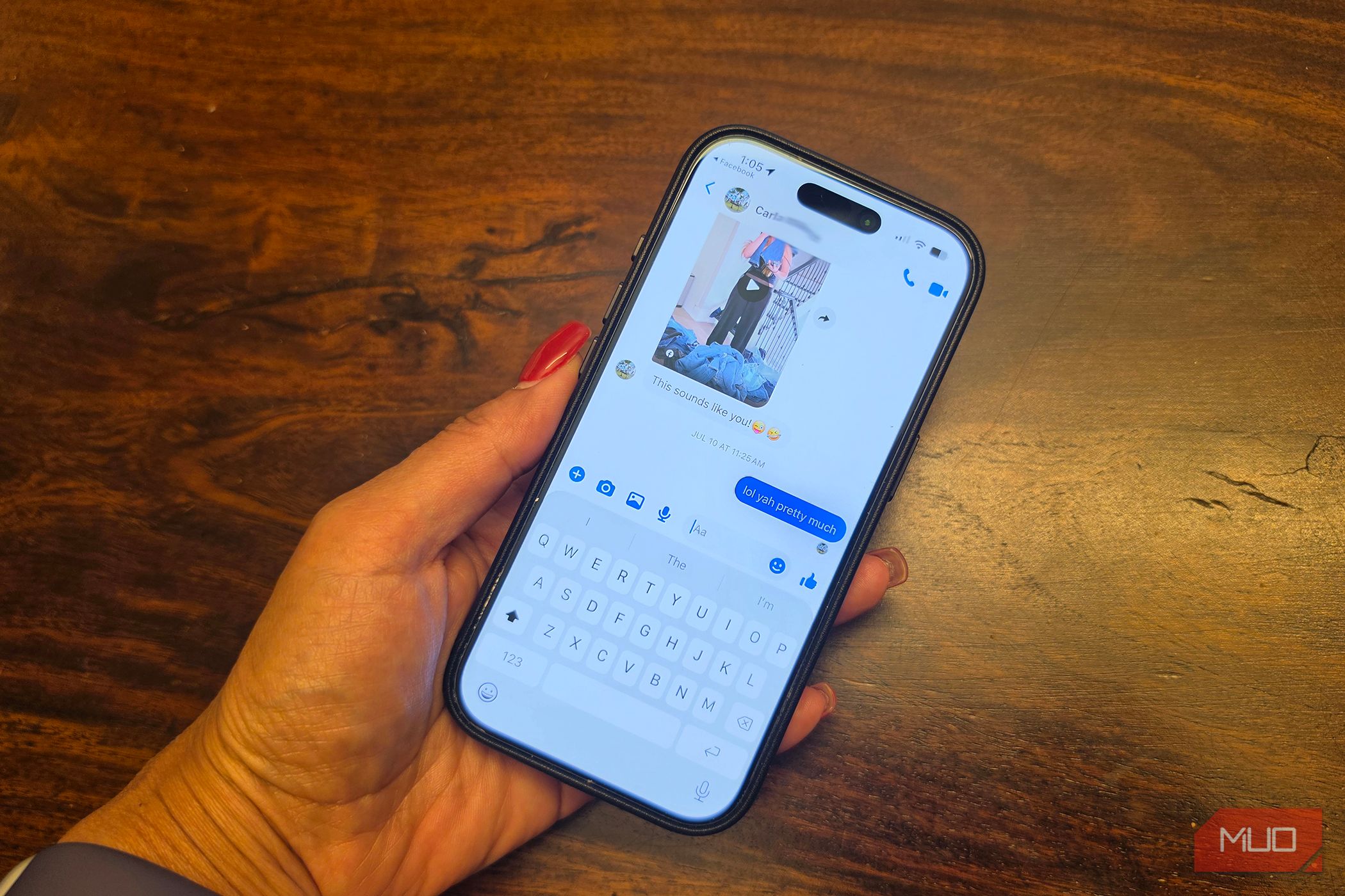An iPhone in hand showing a Facebook Messenger conversation.