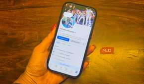 An iPhone in hand showing a Facebook profile.