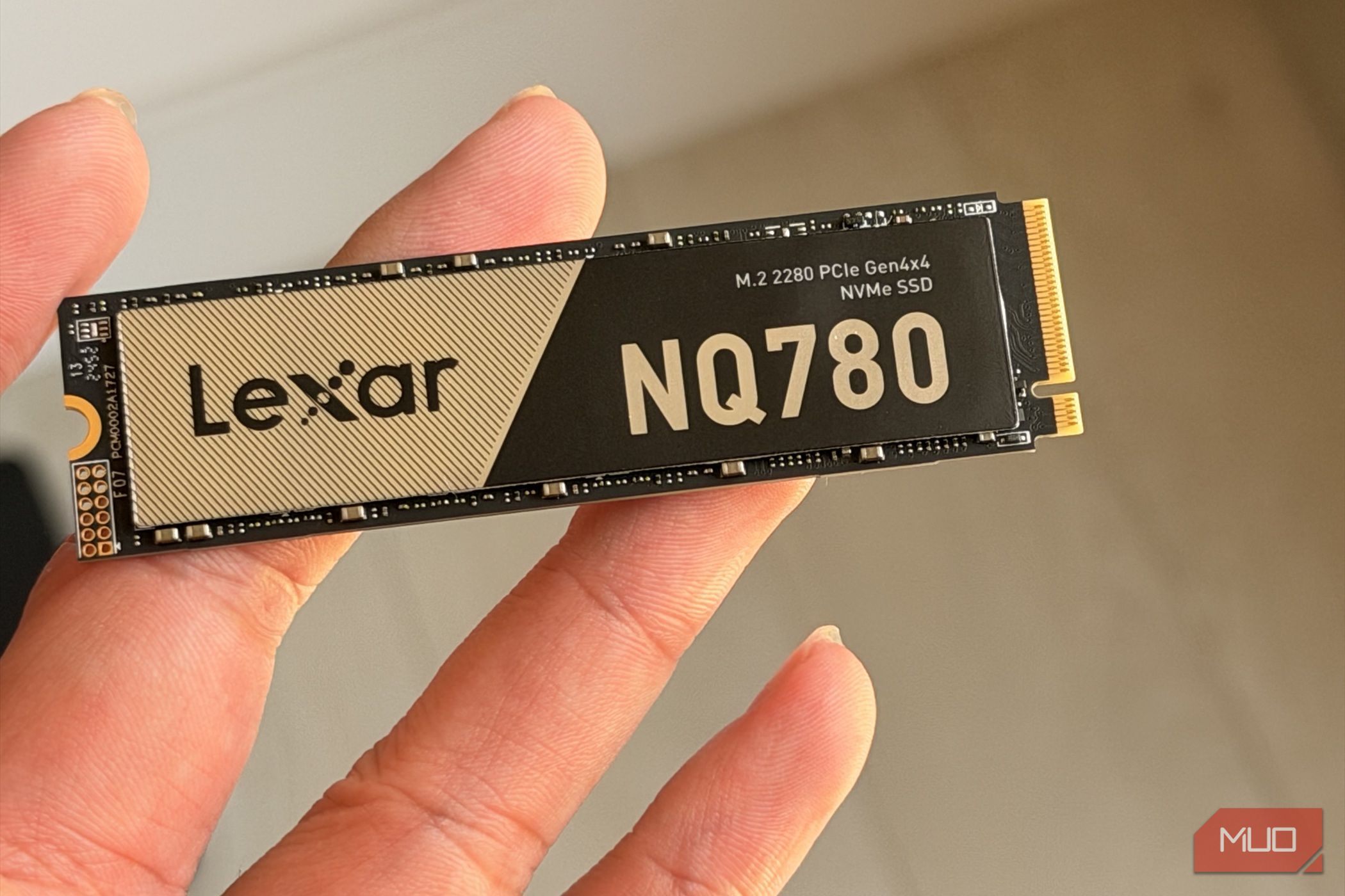 Lexar NQ780 NVMe SSD held between fingers