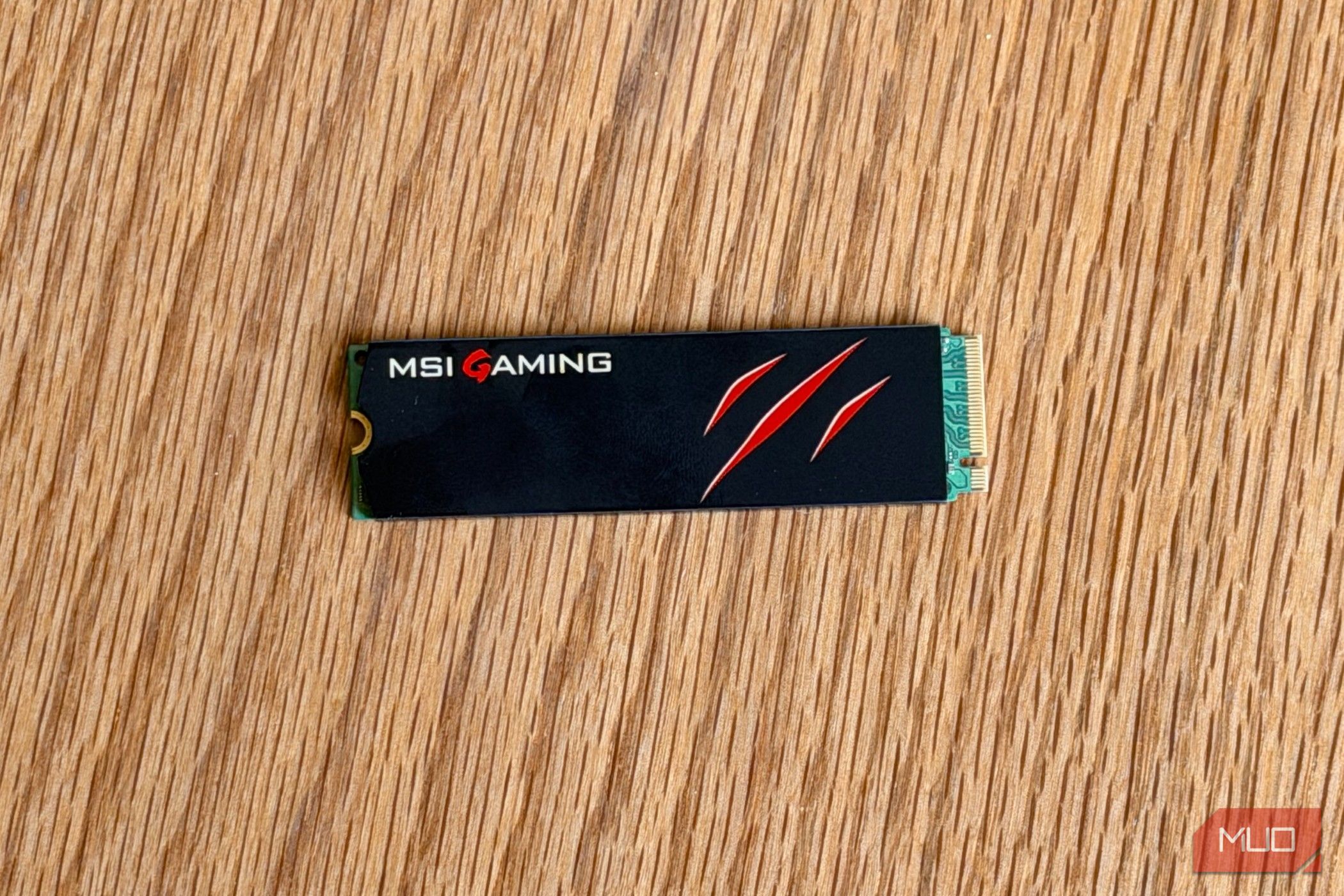 MSI Gaming M.2 NVMe SSD with a claw logo on a wooden desk