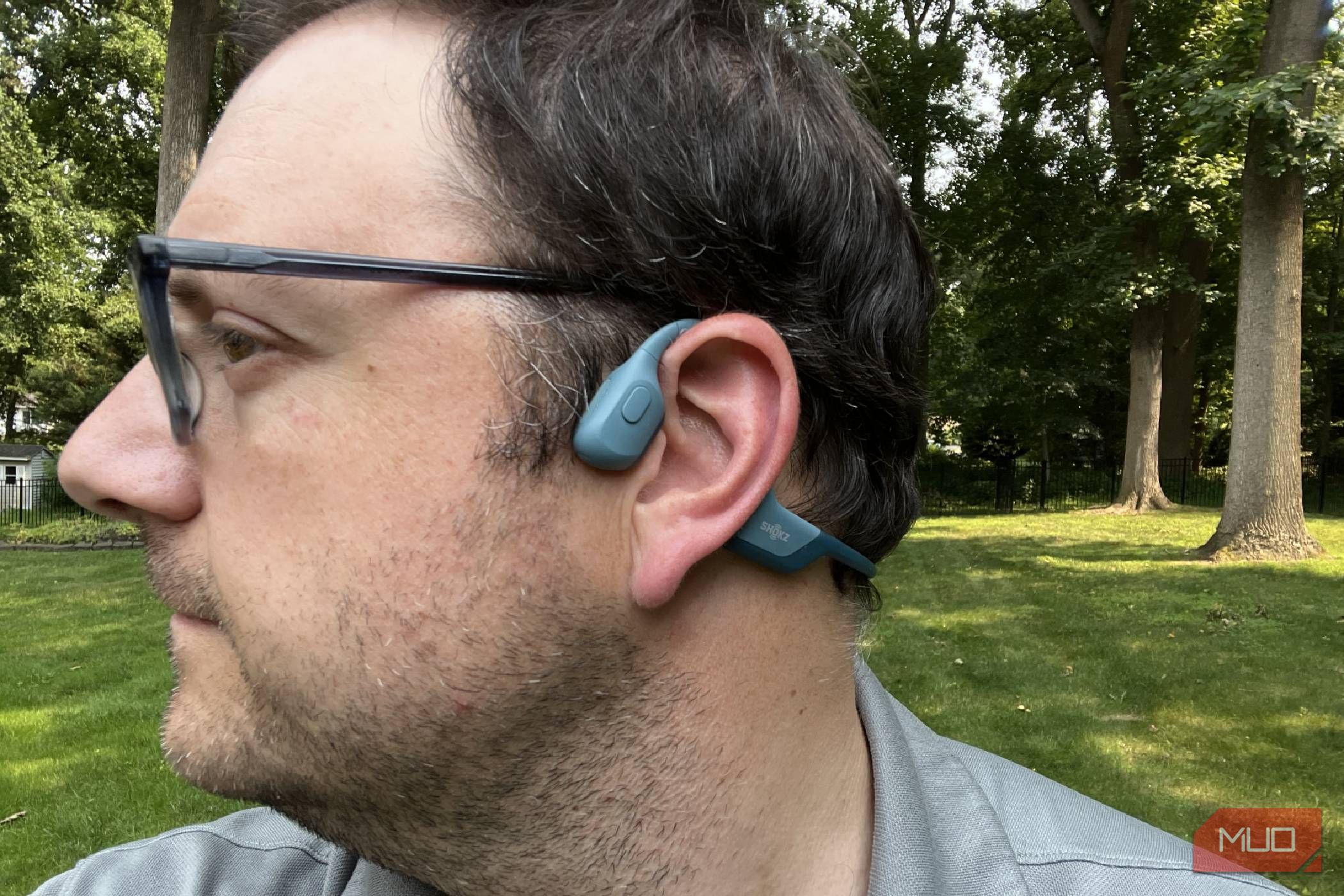 A man wearing Shokz OpenRun Pro headphones on his ears.