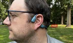 A man wearing Shokz OpenRun Pro headphones on his ears.