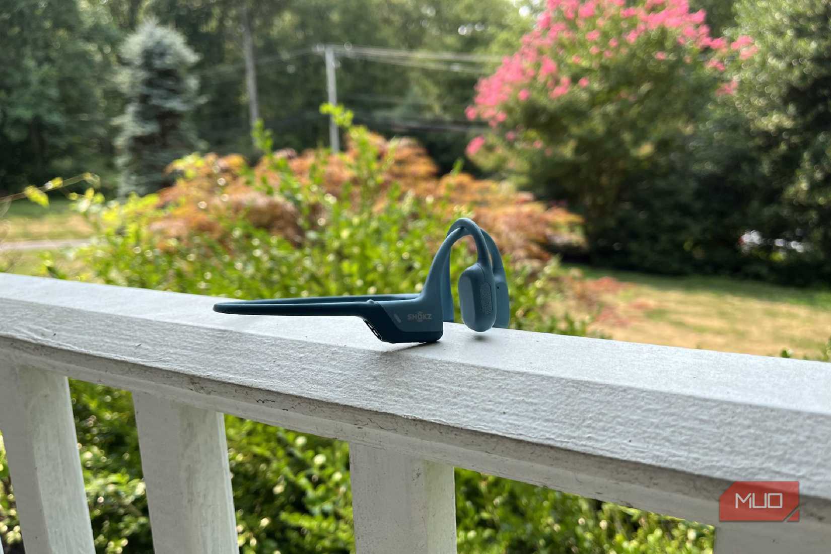 A pair of Shokz OpenRun Pro bone conduction headphones on a porch.