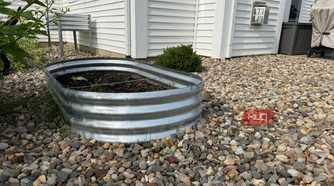 Oval Galvanized Raised Garden Bed Beside White House-1