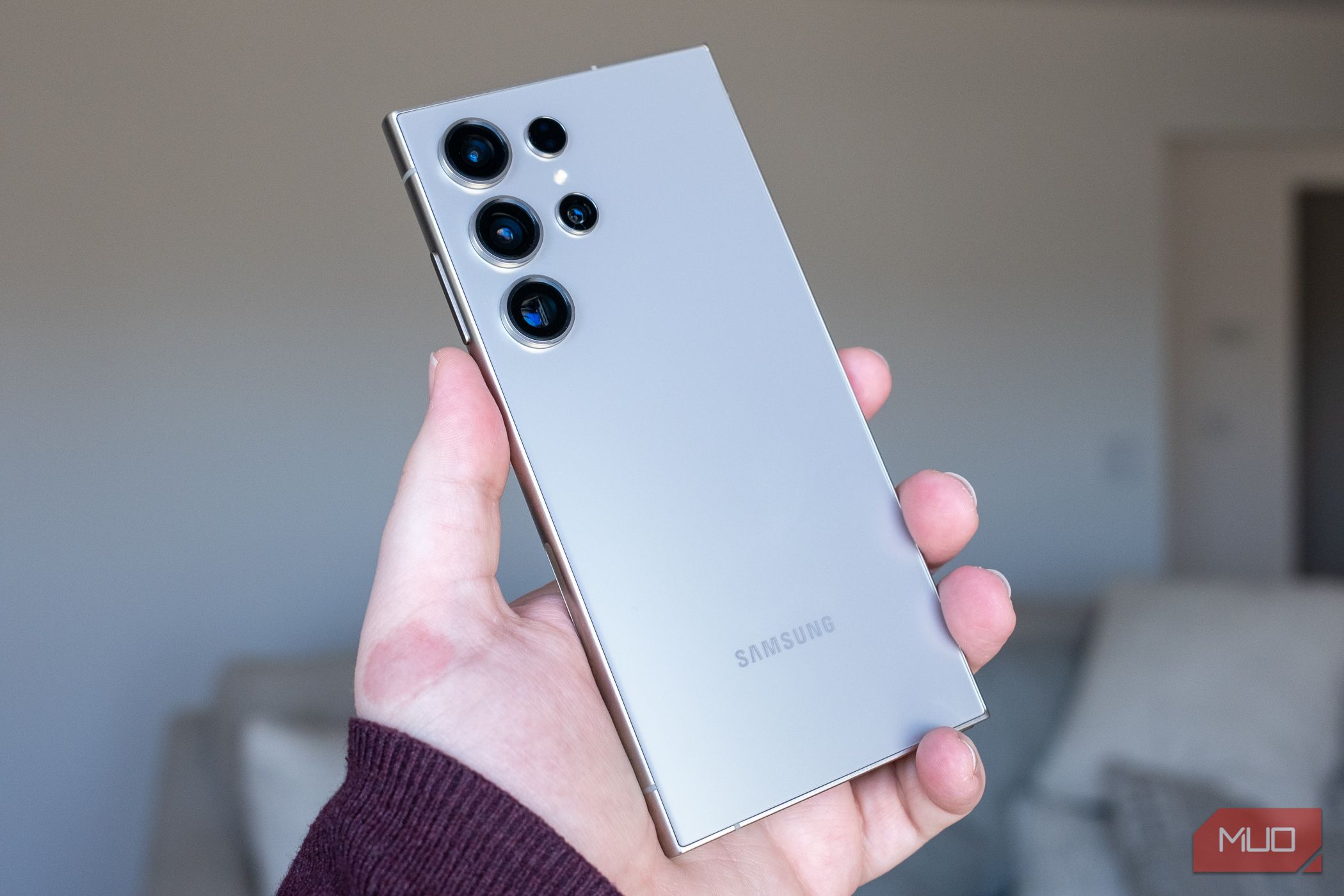 Person holding the Samsung Galaxy S24 Ultra showing the rear cameras