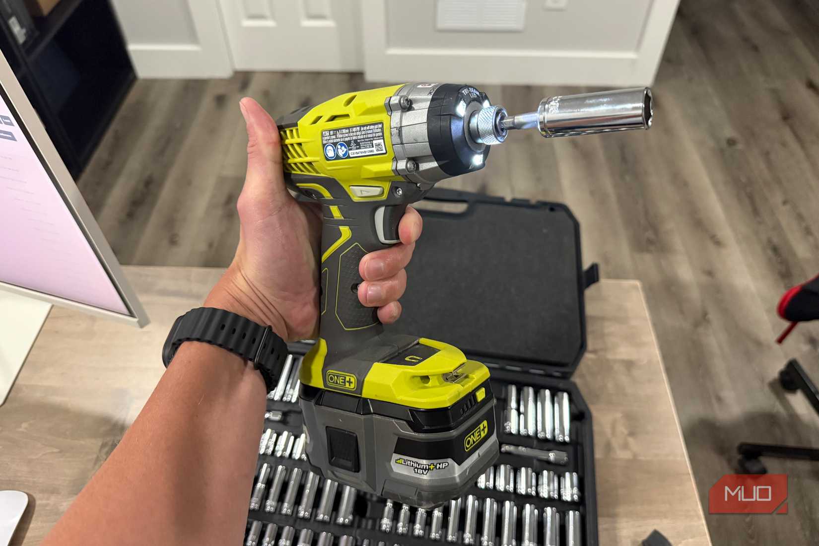 Ryobi impact driver in hand with socket adapter attached