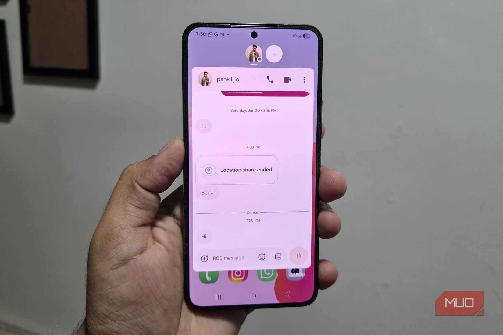 Samsung phone in hand showing messages chat bubbles