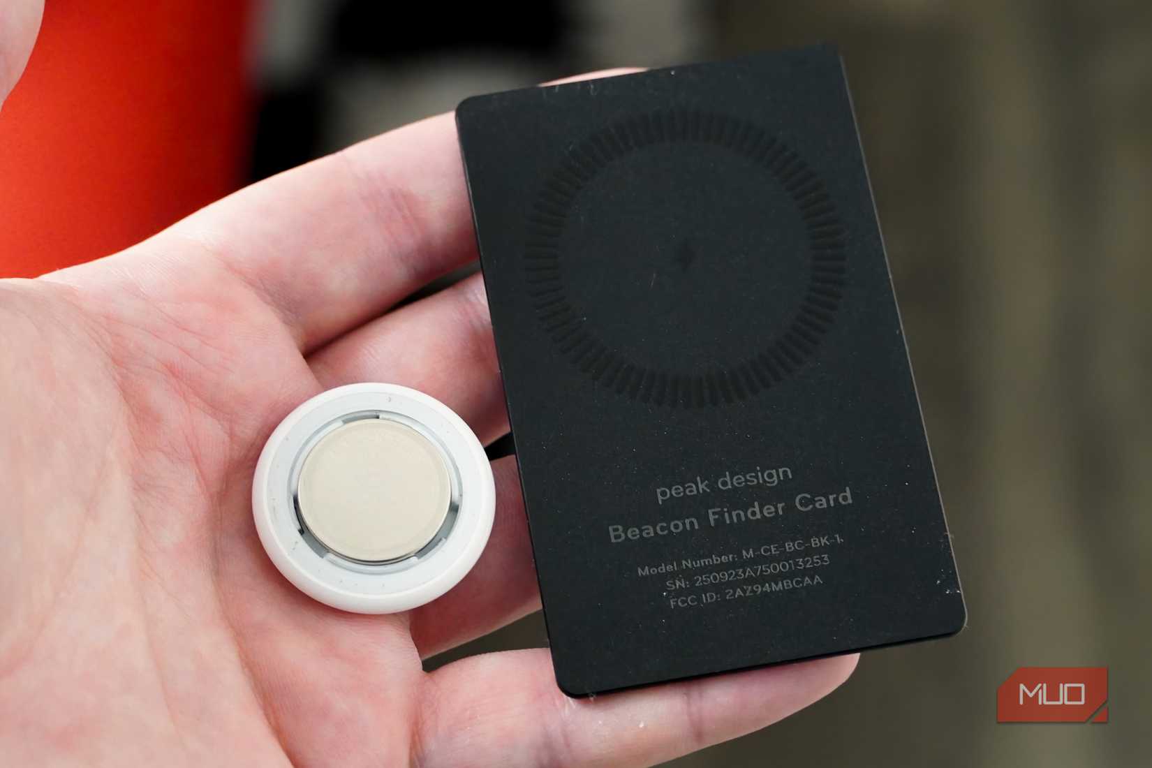 The AirTag with its rear case off beside the tracking card.