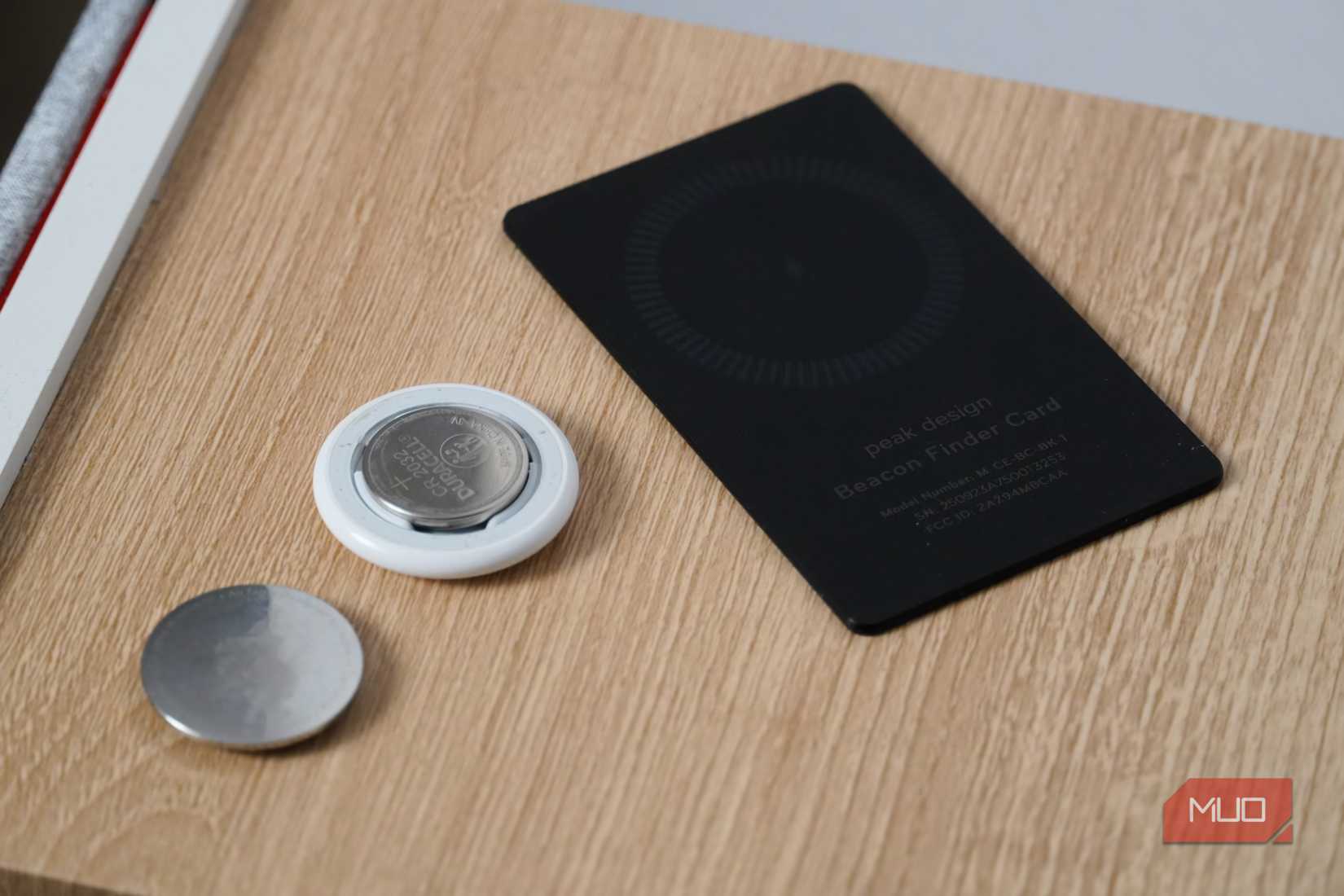 AirTag battery beside a tracking card.