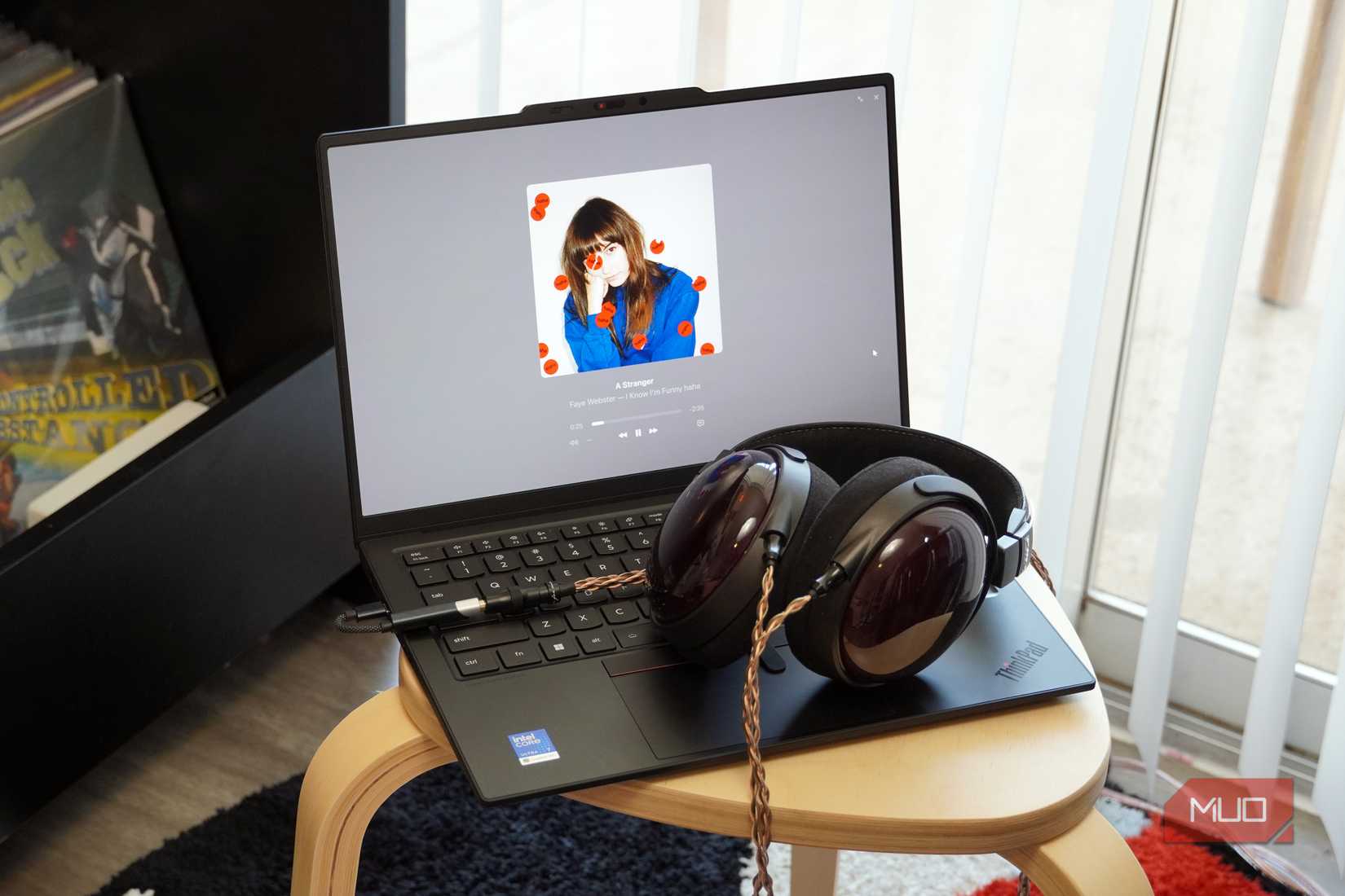 A USB-C DAC and a pair of wired headphones plugged into a Lenovo laptop.