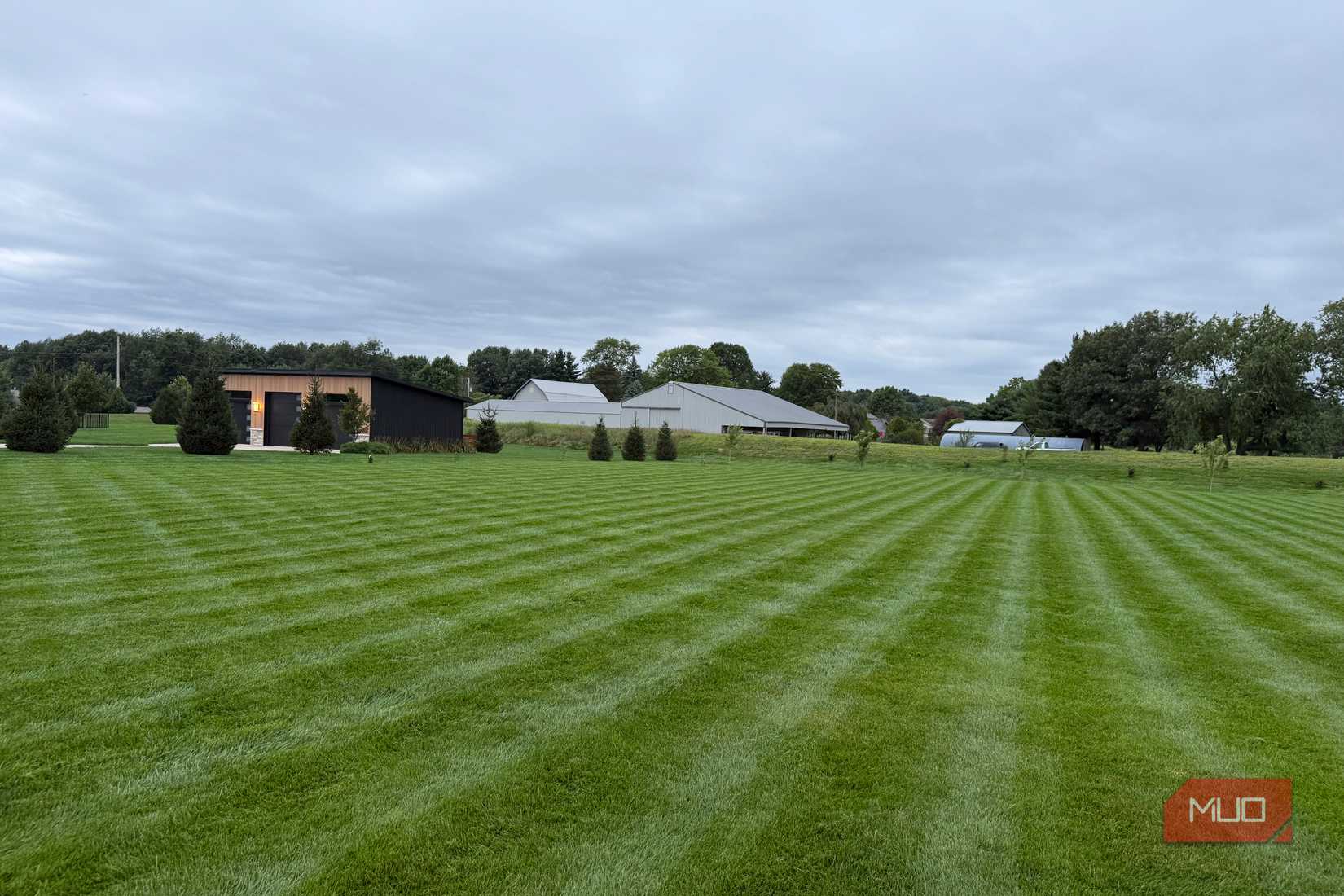 Freshly mowed striped lawn with outbuildings in the distance