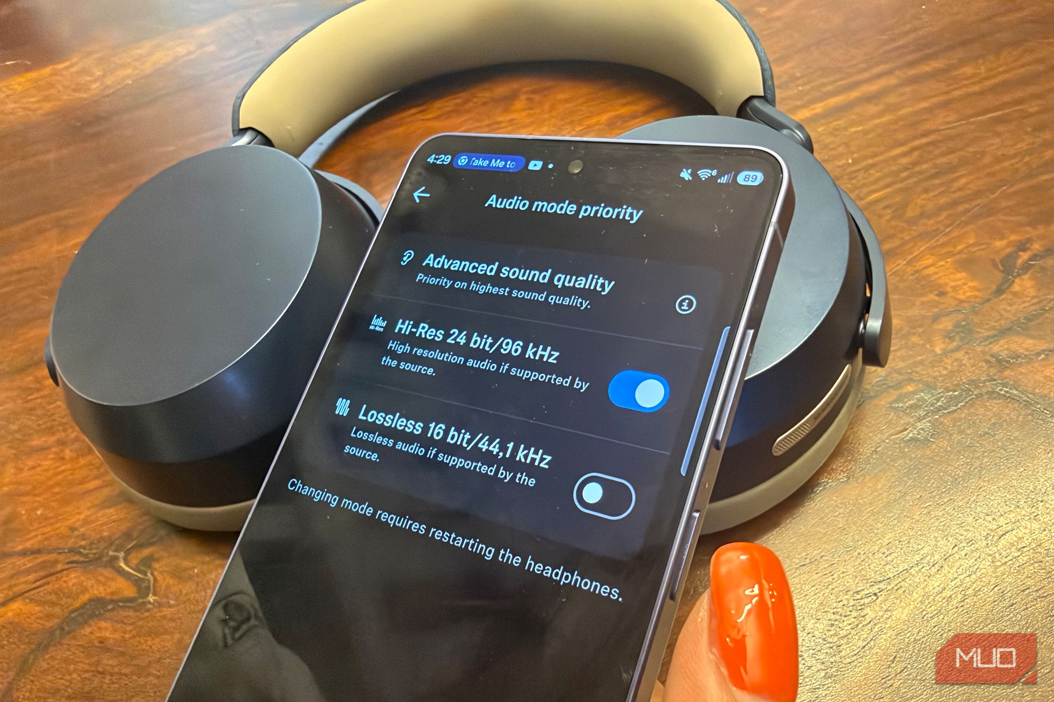 A Samsung Galaxy S26 Ultra showing Hi-Res audio with the Sennheiser Momentum 5 Wireless headphones in the background.