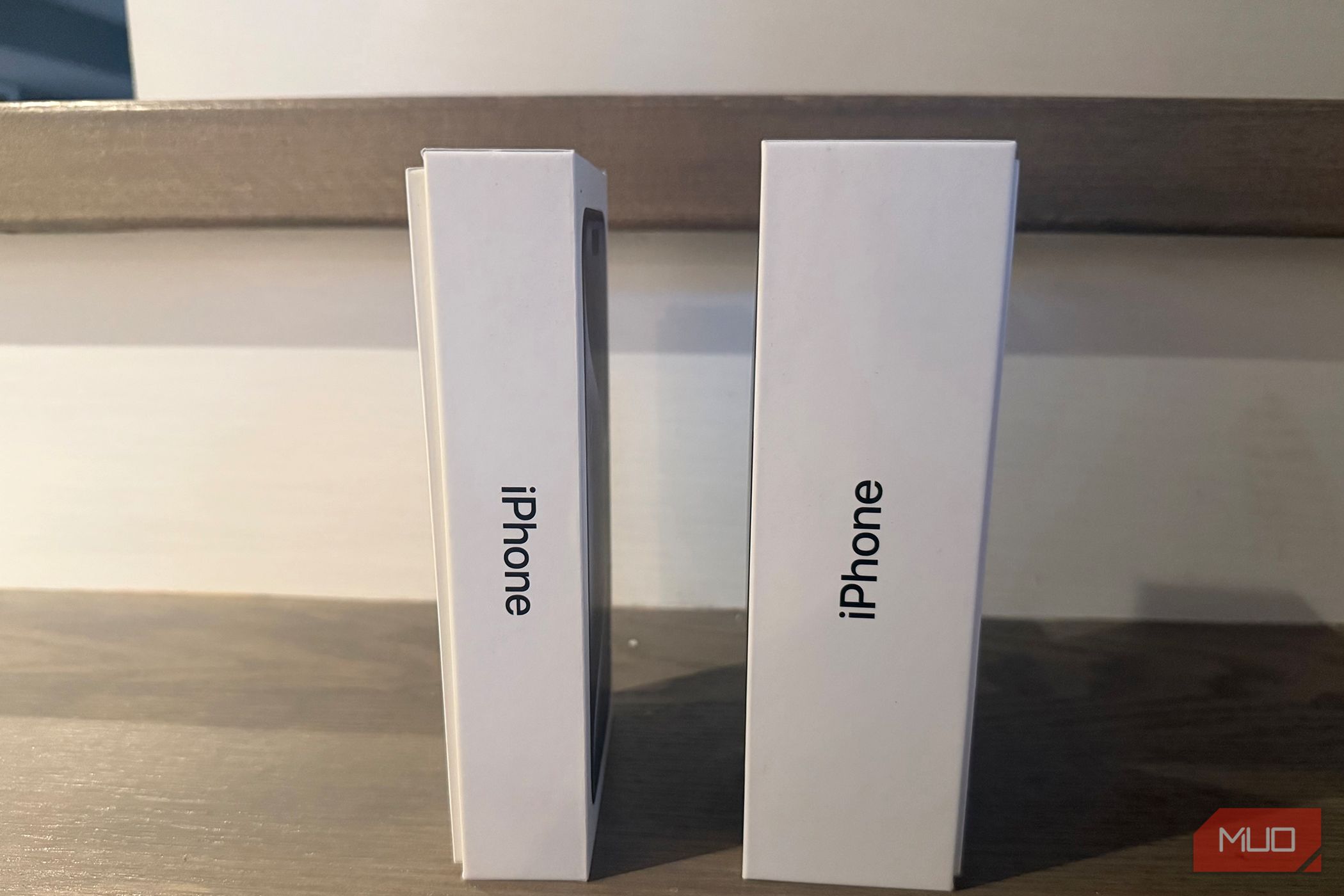 An old iPhone box beside a newer one. 