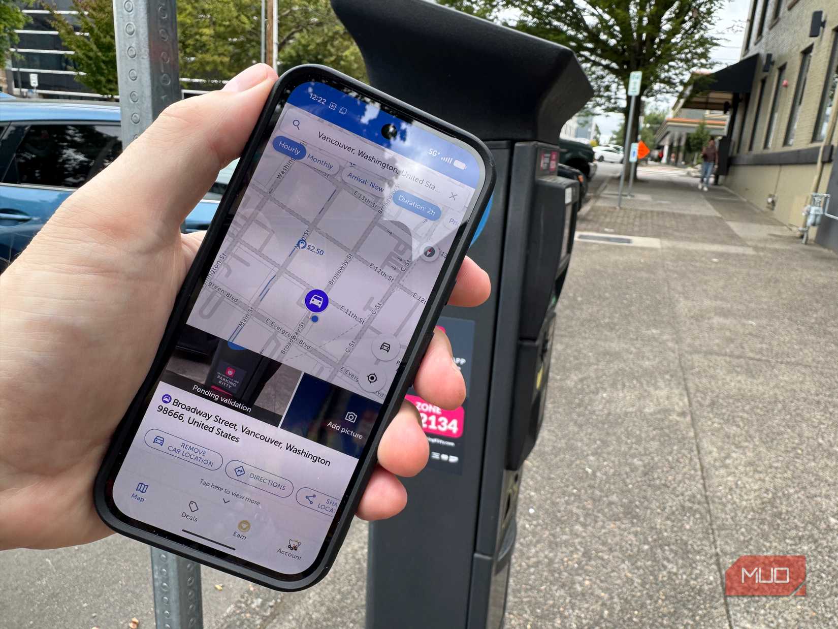 Android phone with SpotAngels app on it at parking meter
