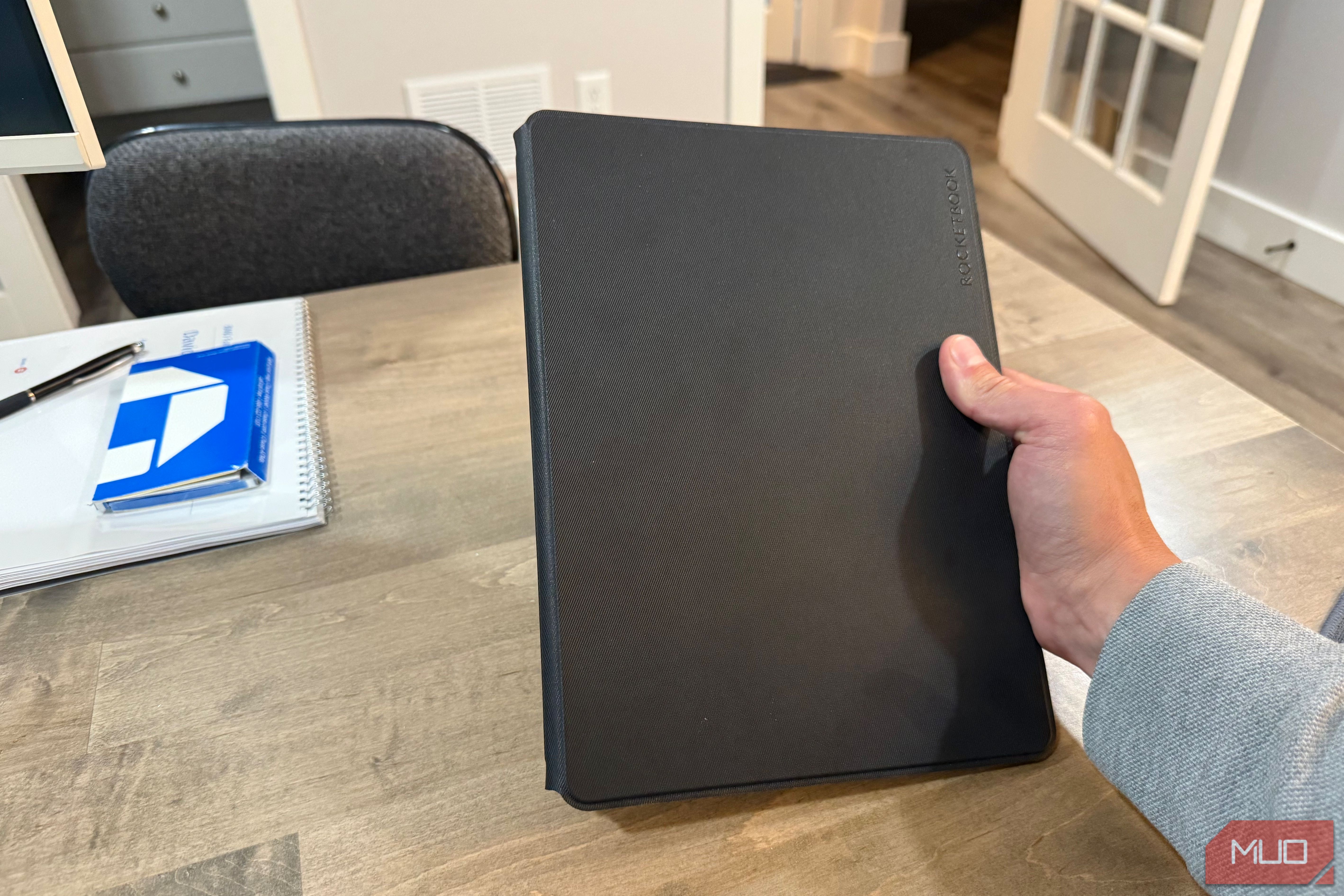 rocketbook pro 2.0 closed held in hand above wooden desk