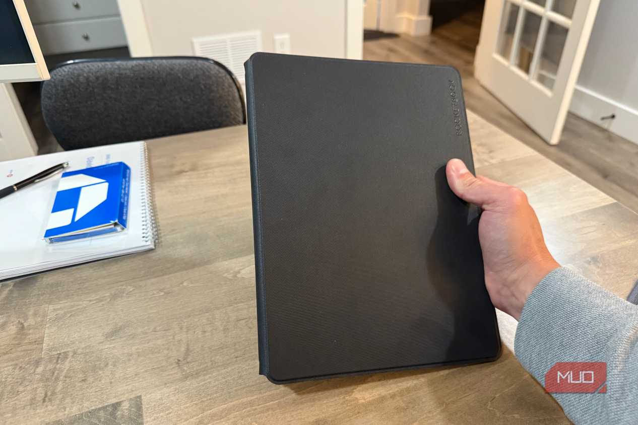 rocketbook pro 2.0 closed held in hand above wooden desk
