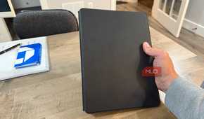rocketbook pro 2.0 closed held in hand above wooden desk