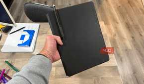 rocketbook pro 2.0 closed held in hand with pen in holder above desk