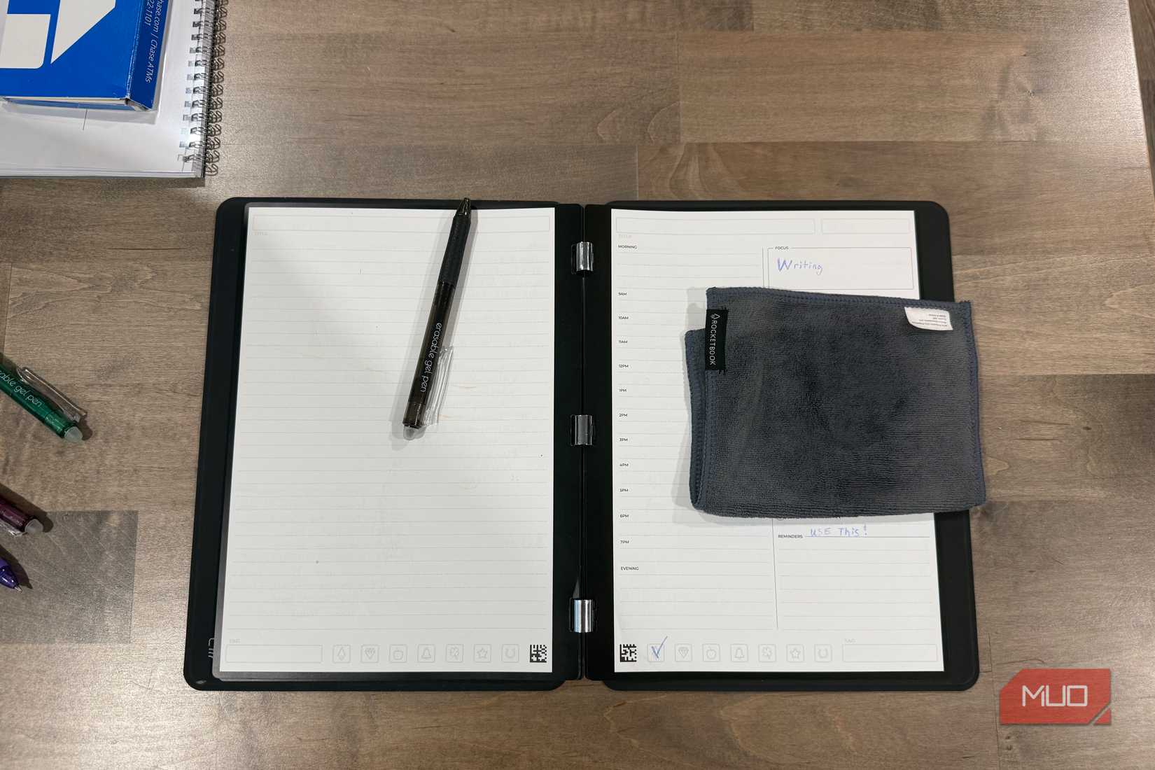 rocketbook pro 2.0 open flat with black pen and folded microfiber cloth
