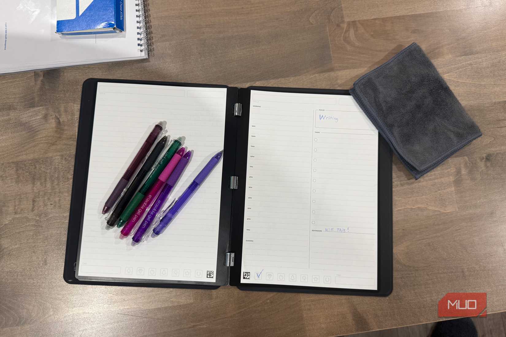 rocketbook pro 2.0 open flat with colorful erasable pens and microfiber cloth