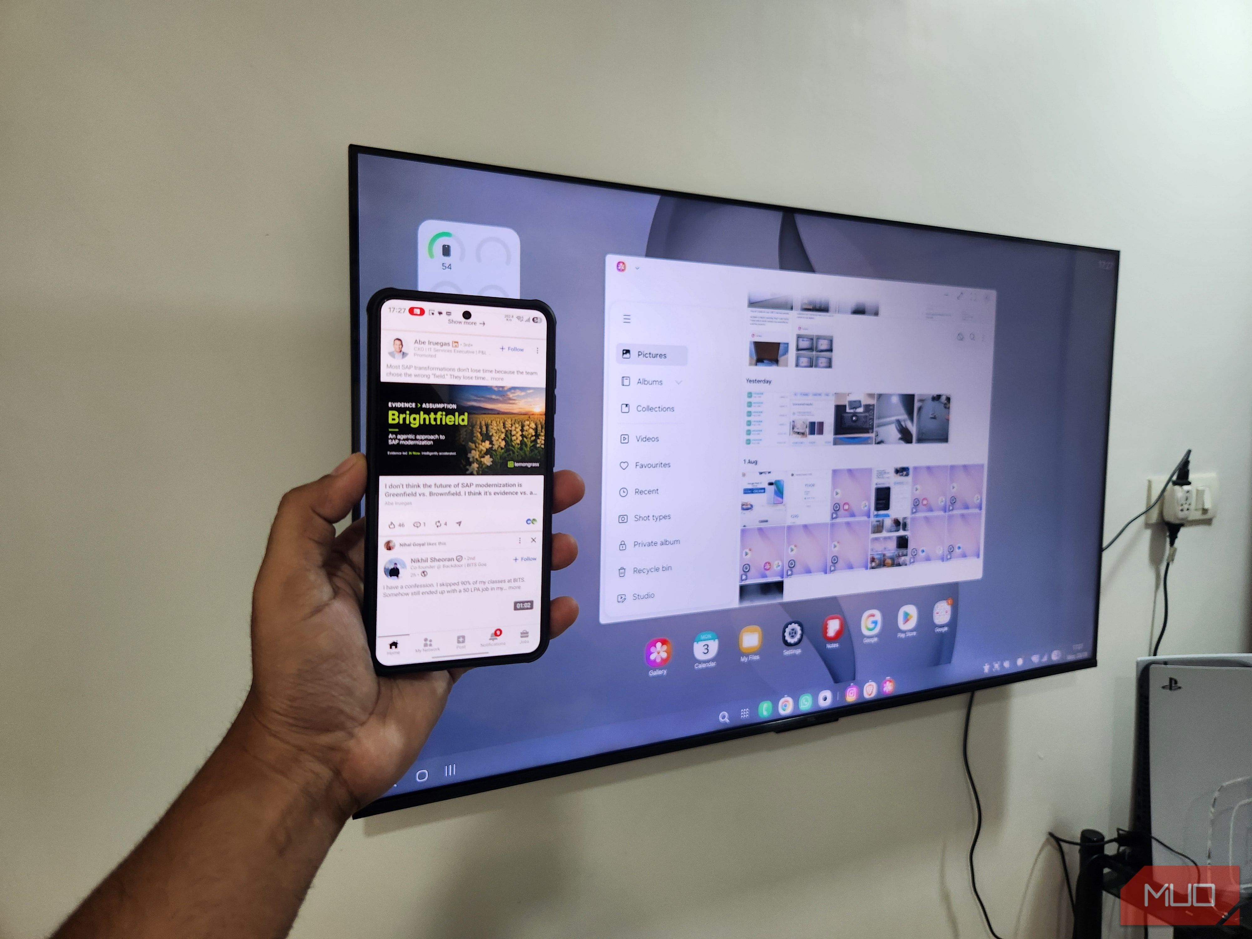 Samsung DeX on TV and a Galaxy phone in hand