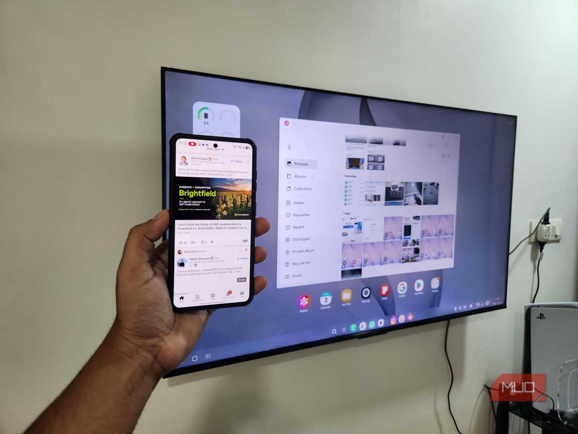 Samsung DeX on TV and a Galaxy phone in hand
