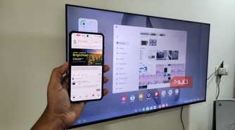 Samsung DeX on TV and a Galaxy phone in hand