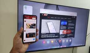Samsung DeX on TV and Galaxy S26 phone in hand