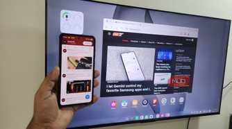 Samsung DeX on TV and Galaxy S26 phone in hand