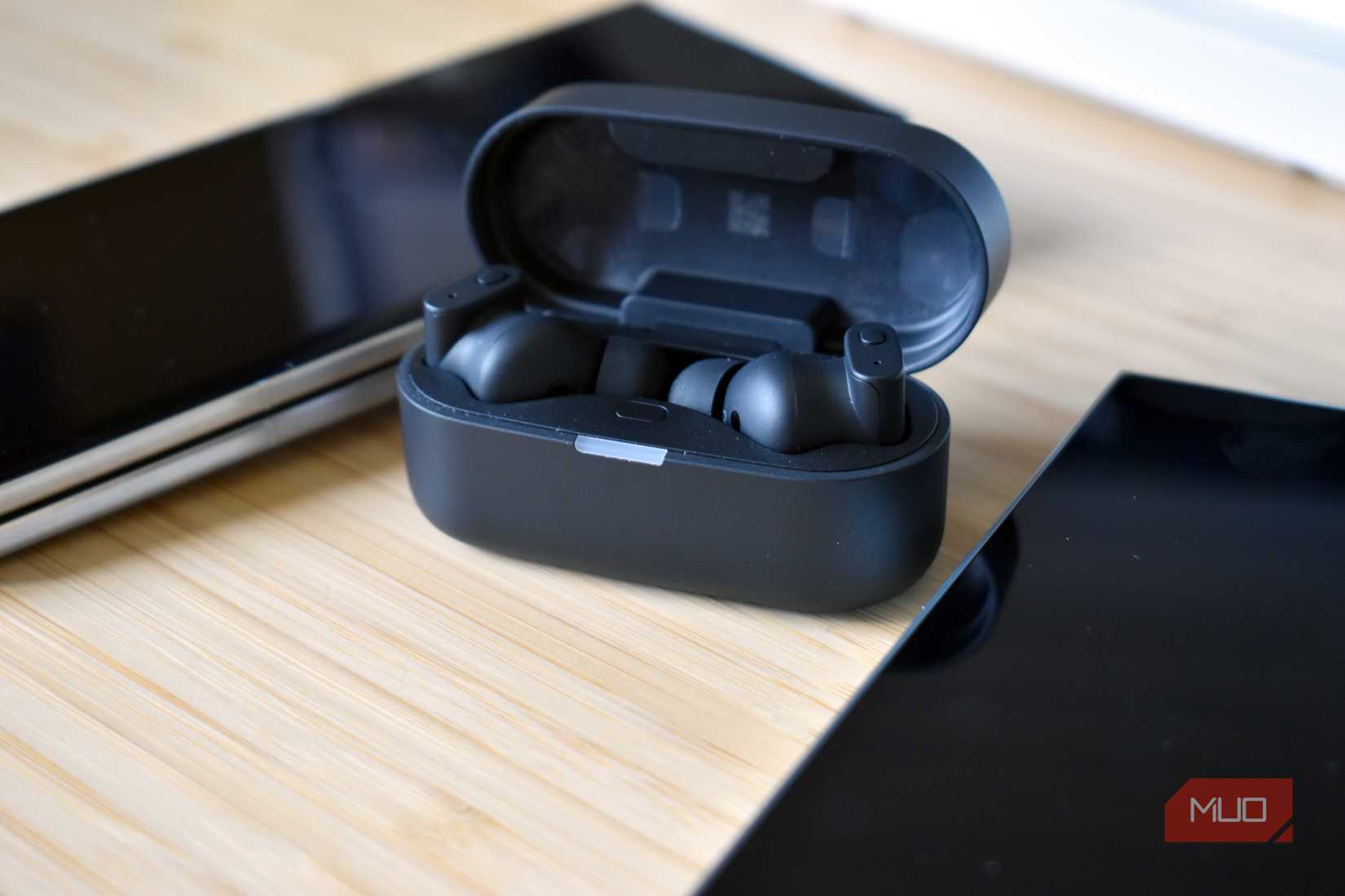 status pro x earbuds in case on desk.
