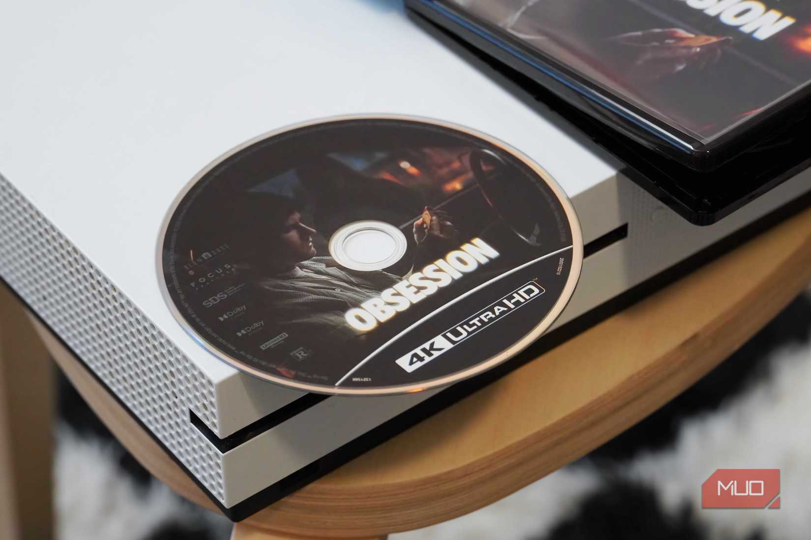 Xbox One S with a 4K UHD Blu-ray disc on top.