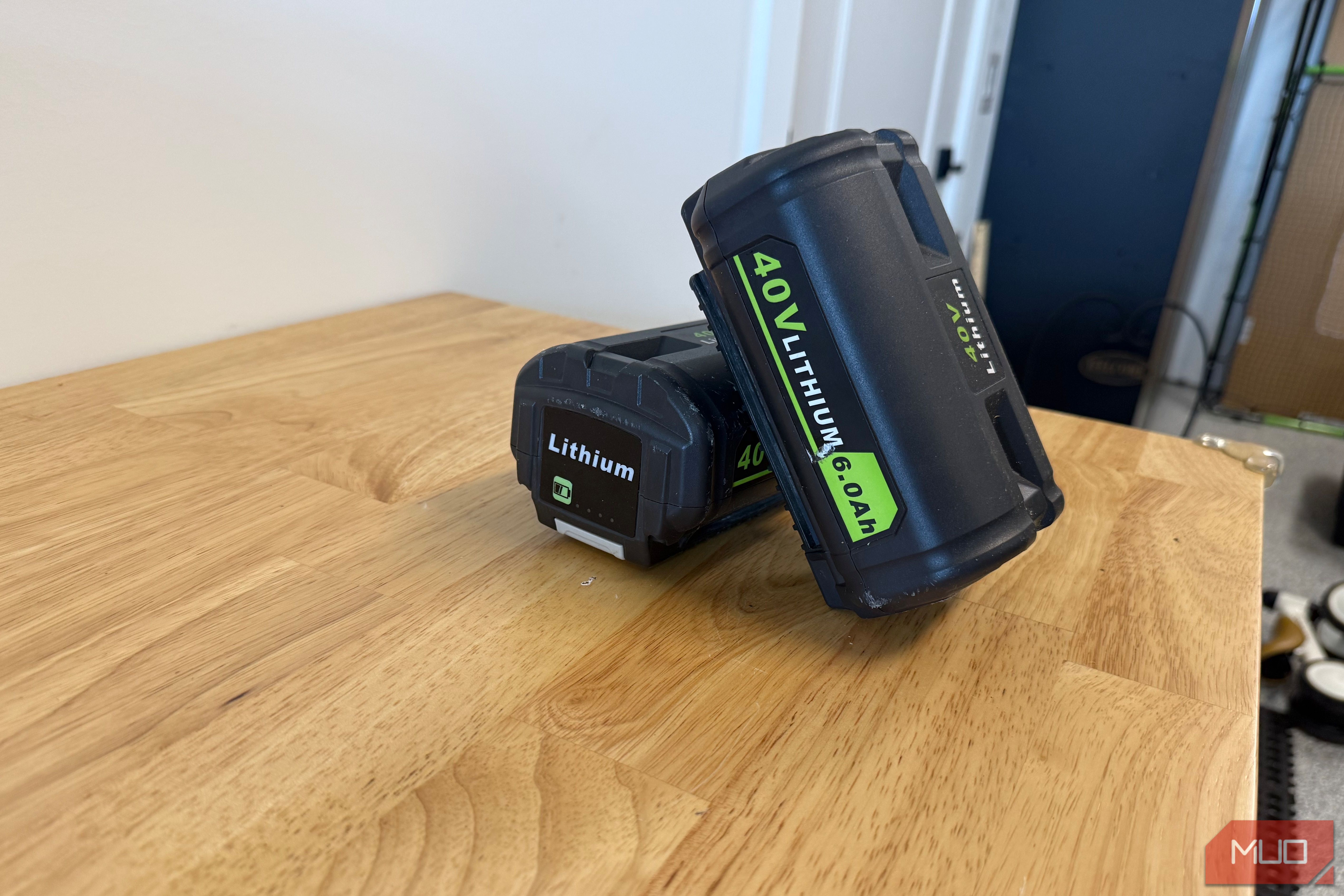 2 off-brand ryobi 40V 6.0Ah batteries leaning together on workbench