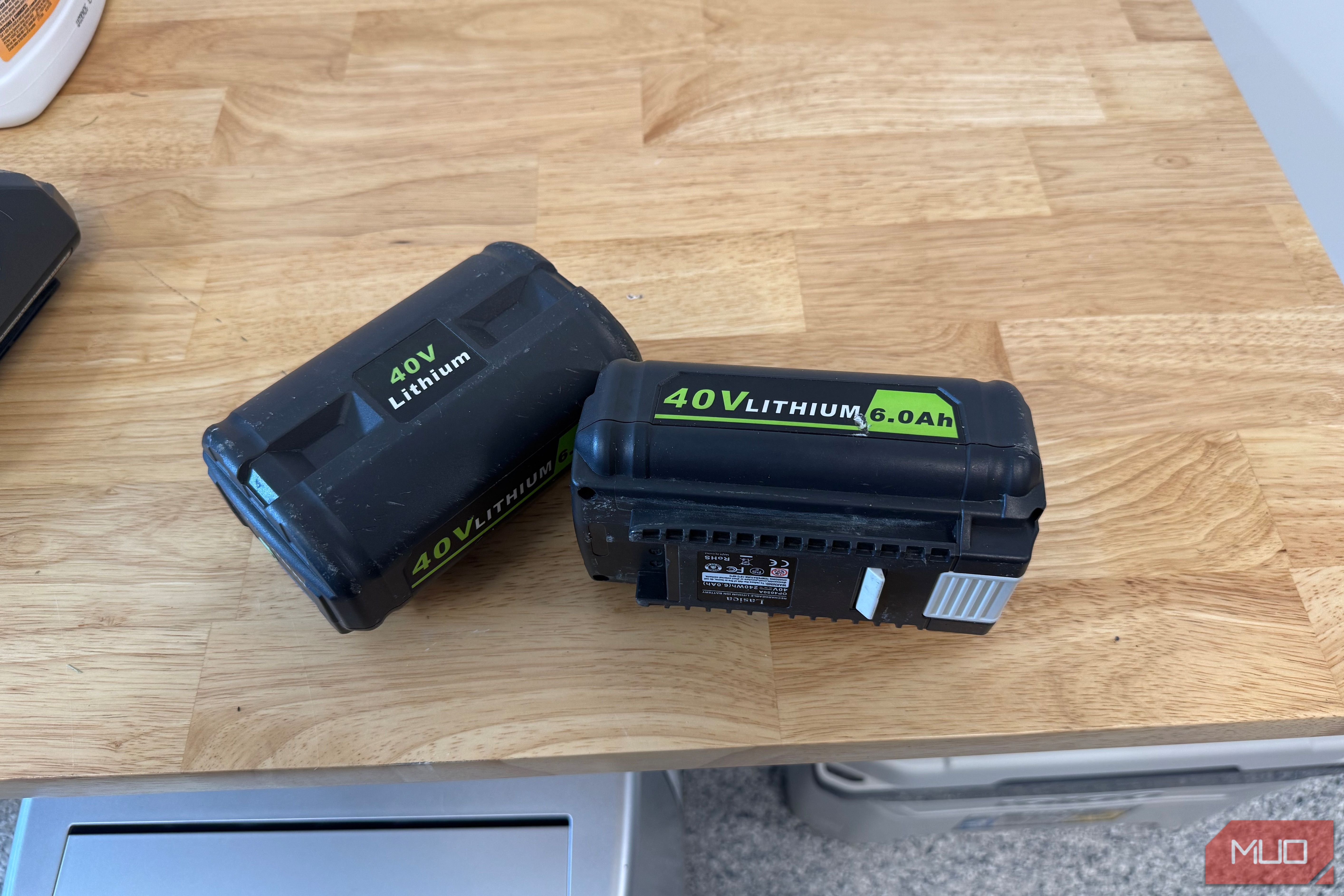 2 off-brand ryobi 40V 6.0Ah batteries lying on wooden counter