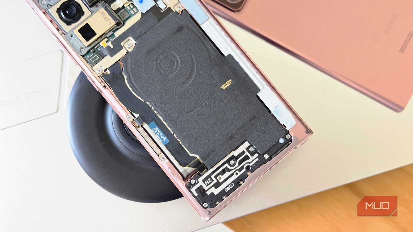 disassembled Note 20 Ultra on wireless charger showing internal components and battery