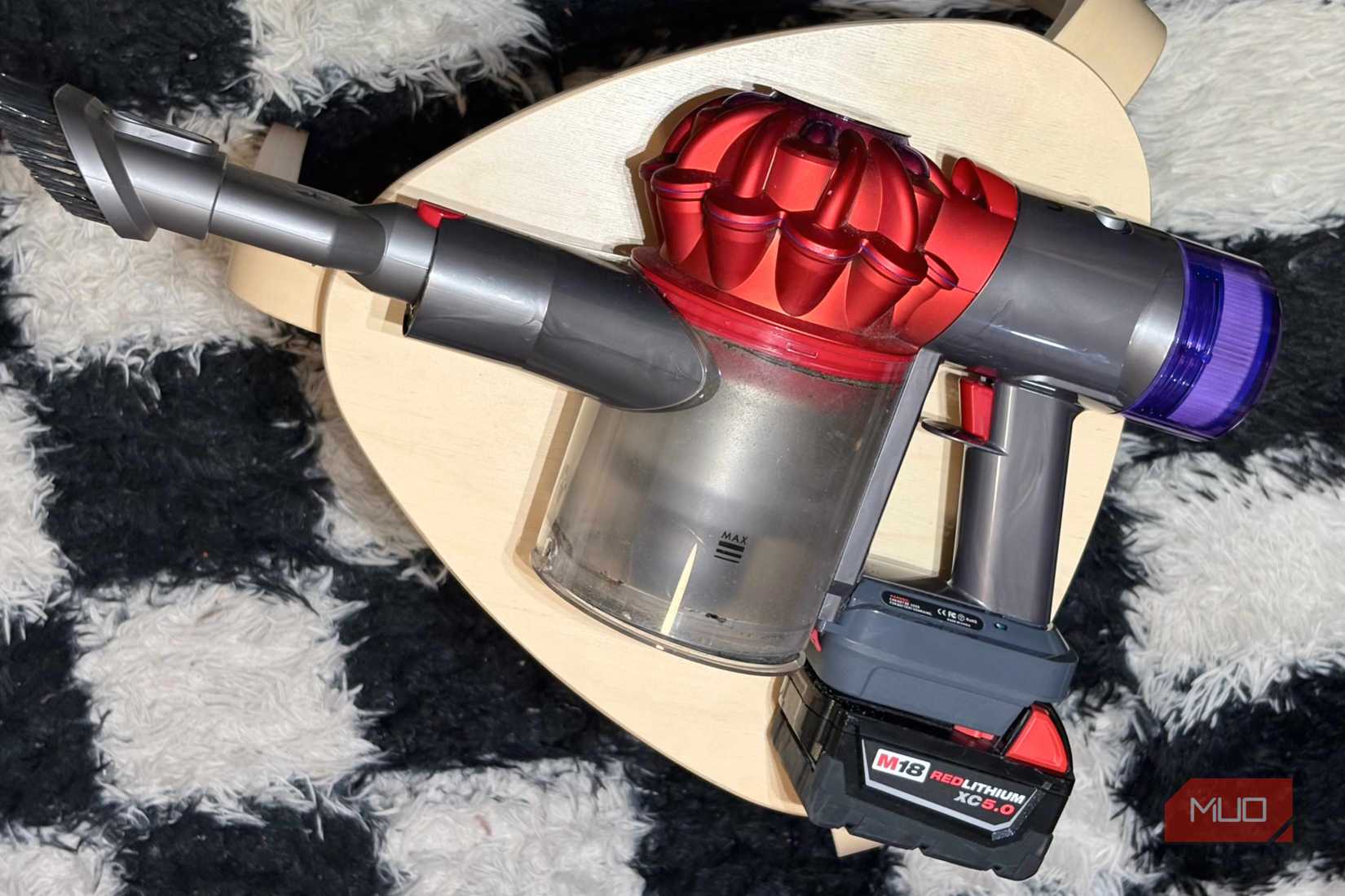 A Milwaukee M18 battery attached to the Dyson V8 vacuum.