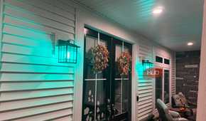 Front porch lanterns glowing teal with Linkind smart bulbs at night