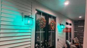 Front porch lanterns glowing teal with Linkind smart bulbs at night
