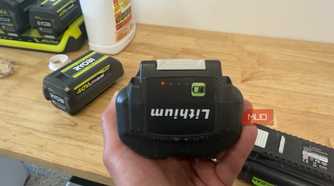 hand holding off-brand ryobi 40V battery showing charge indicator lights