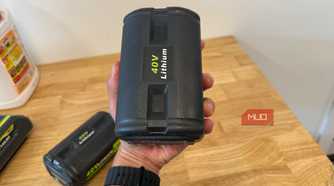 hand holding off-brand ryobi 40V lithium battery upright over workbench